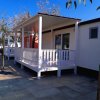 Casa mobile con veranda bianca e pavimento piastrellato.