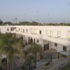 Complesso residenziale bianco con palme.