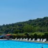 Piscina esterna con lettini e colline sullo sfondo.