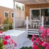 Veranda di bungalow con vasca e fiori rosa.