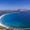 Spiaggia con sabbia bianca e mare azzurro.