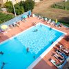 Persone in piscina e lettini attorno.