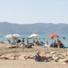 Spiaggia con persone, ombrelloni e mare azzurro sullo sfondo.
