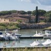 Barche attraccate in un porto con edifici sullo sfondo.