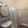 Bagno con specchio rotondo e doccia.