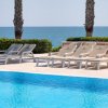 Lettini a bordo piscina con vista mare.