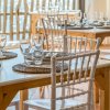 Tavoli apparecchiati in un ristorante con sedie bianche.