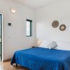 Camera con letto blu e uscita su balcone.