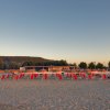 Spiaggia con sdraio e ombrelloni arancioni.