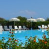 Piscina con lettini e ombrelloni bianchi.