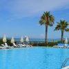 Piscina con lettini e mare.