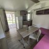Interno di una casa mobile con tavolo, sedie e divano rosa.
