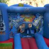 Un castello gonfiabile blu con decorazioni spaziali, bambini giocano all'interno.