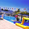 Piscina con decorazioni colorate e sdraio blu sotto un cielo sereno.