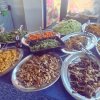 Un buffet con vari piatti di verdure e funghi su vassoi d'acciaio.