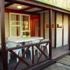 Veranda di legno con tavolo e sedie bianche.