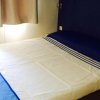 Letto matrimoniale con lenzuola bianche e blu.