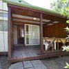 Veranda in legno con tavolo e sedie bianche.