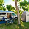 Camper e tenda in un'area verde con biciclette.