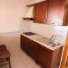 Cucina compatta con mobili in legno e due sedie.