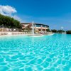 Piscina con getto d'acqua e sdraio.