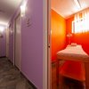 Corridoio viola con stanza massaggi arancione.