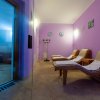 Sala relax viola con chaise longue.