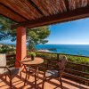 Balcone con tavolino, sedie e vista mare.