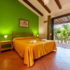 Camera con letto matrimoniale, parete verde e accesso a una terrazza.