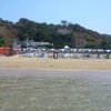 Spiaggia con ombrelloni a righe blu e bianche.