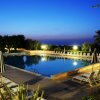 Piscina illuminata al tramonto con lettini.