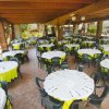 Ristorante con tavoli rotondi apparecchiati.