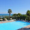 Piscina circondata da sedie e alberi.